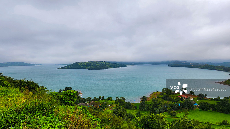 宁静的海湾景色，郁郁葱葱的绿植和阴云密布的天空，阿科莱，印度图片素材