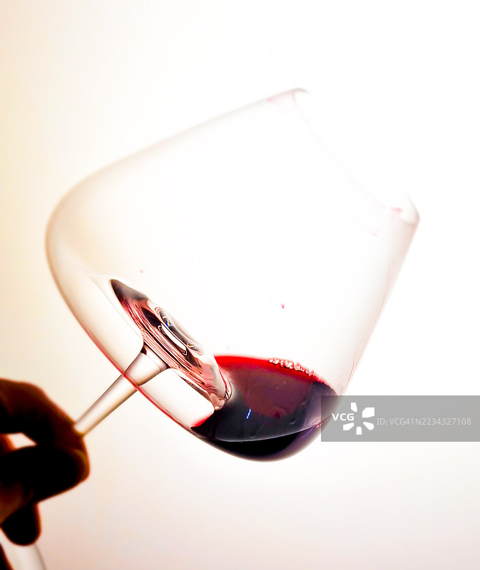 手握红酒杯，背景为白色图片素材