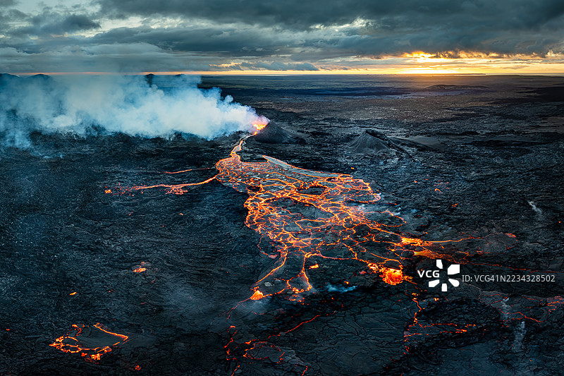 日落时分冰岛火山喷发的空中视角，熔岩流动。图片素材