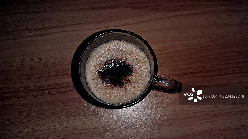 木桌上玻璃杯中的咖啡俯视图图片素材
