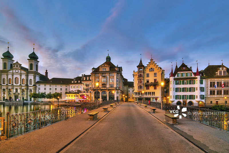 瑞士卢塞恩州的卢塞恩老城与耶稣教堂在黎明时分从瑞乌斯桥的视角图片素材