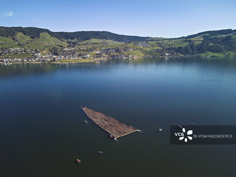 林业工人将砍伐的树干筏漂浮过艾格湖到达港口，2025年，乌特拉根，楚格州，瑞士图片素材