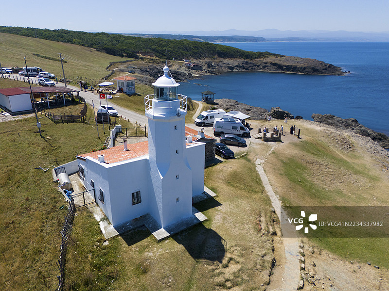 海岸边的灯塔,附近有移动房屋,周围环绕着草甸和岩石,背景是海平线,航拍视角,灯塔,伊切布伦(İnceburun),伊切布伦是安纳托利亚最北端,位于土耳其锡诺普省。图片素材