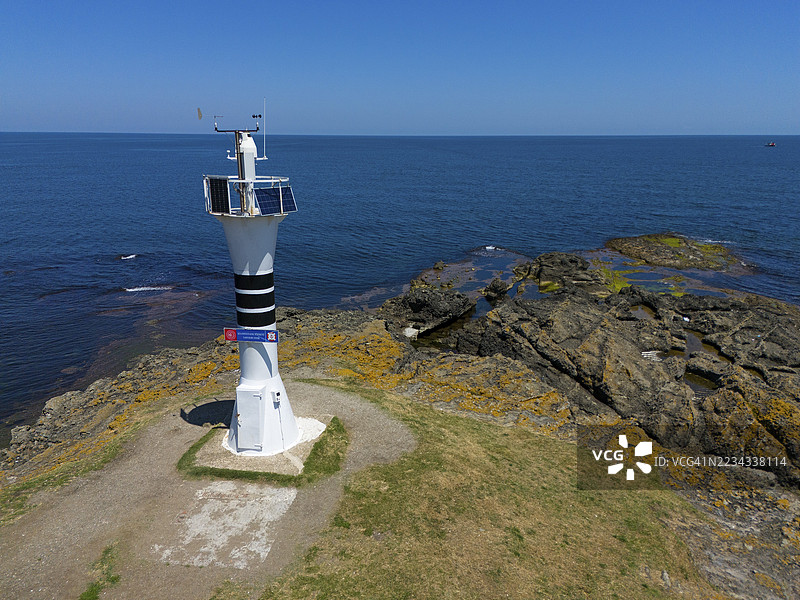 岩石海岸上的灯塔特写，宽广的海洋和蓝天，鸟瞰图，雅松角灯塔，杰森角，Çaytepe，土耳其奥尔杜省图片素材