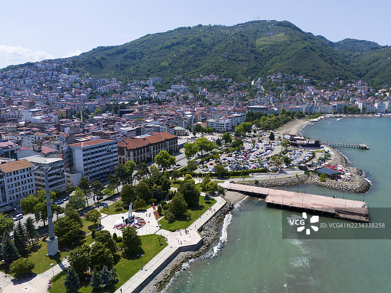 土耳其奥尔杜省阿尔廷奥尔杜的海滨小镇，山丘上密集的建筑、绿地和沿海滨的步道，鸟瞰图图片素材