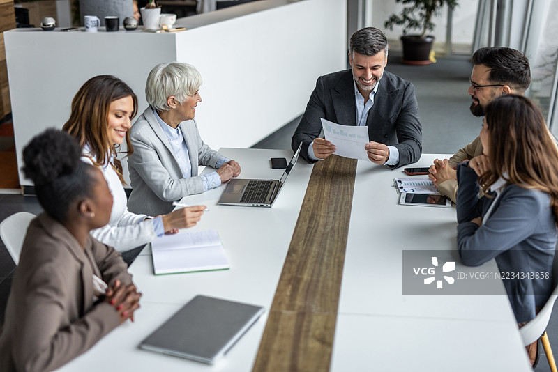 商业团队在现代办公室讨论财务结果图片素材