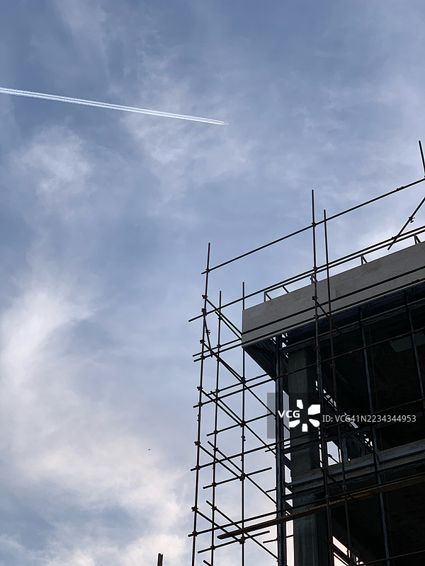 伊朗塔布里兹的建筑脚手架与多云的天空和飞机尾迹图片素材