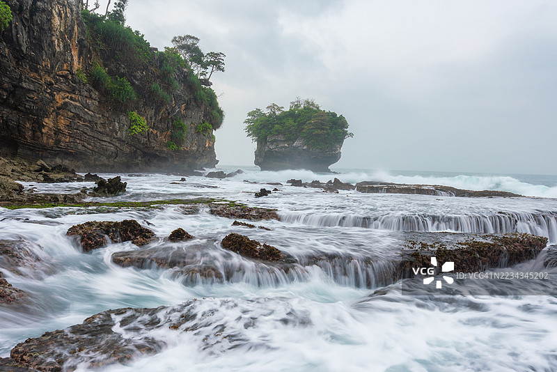 印度尼西亚萨瓦尔纳的戏剧性海岸风景，波浪撞击岩石悬崖图片素材