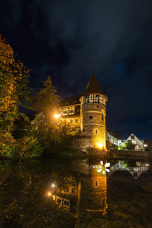 夜晚，巴林根，德国，照亮的中世纪建筑倒映在水中图片素材