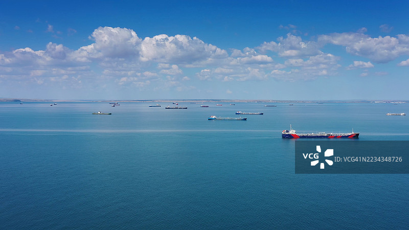 货船在蓝天的平静海面上航行图片素材