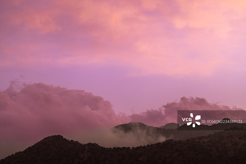 山脉剪影映衬着绚丽的日落天空，沙特阿拉伯塔伊夫图片素材