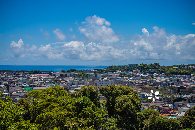 日本新宫市的海滨小镇风景，绿树成荫，蓝天白云。图片素材
