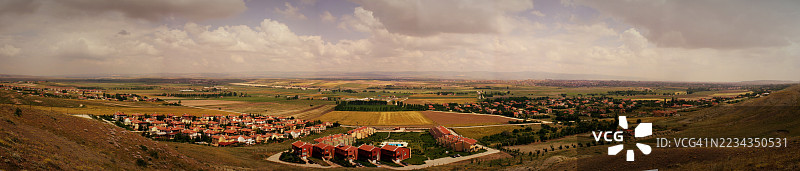 土耳其乡村风景的全景，田野和房屋在多云的天空下。图片素材