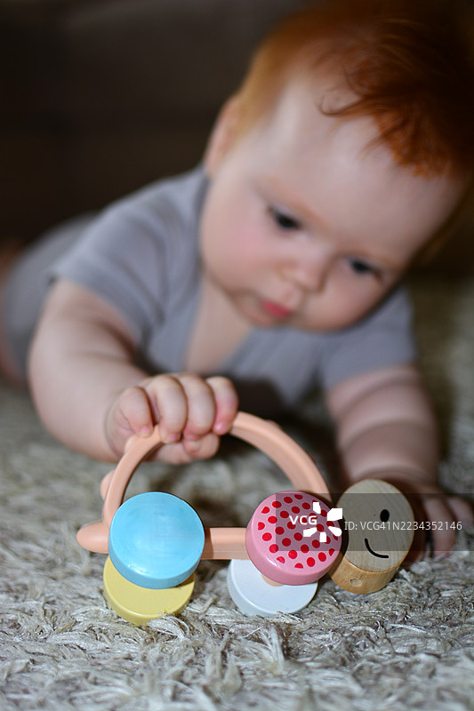 小女孩在家在地毯上玩彩色的玩具图片素材