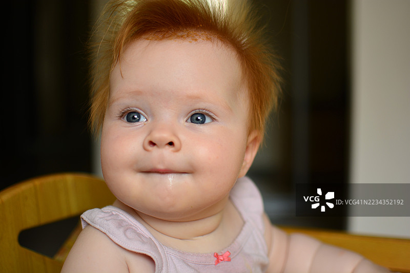 红发女婴室内坐着图片素材