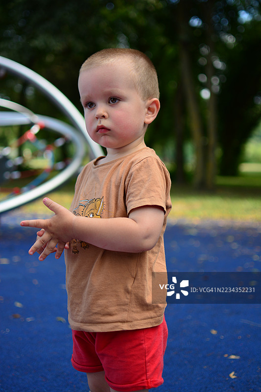 一个小男孩站在游乐场里图片素材