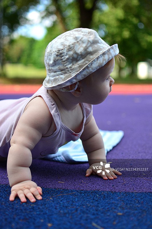 婴儿在色彩鲜艳的户外垫子上爬行图片素材