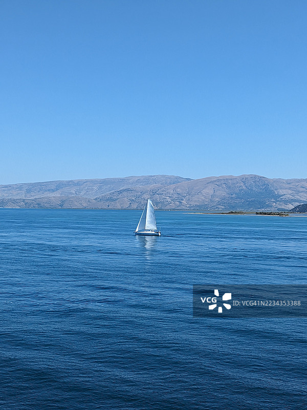 在清澈蓝天下，宁静海面上的帆船，科孚岛，希腊图片素材
