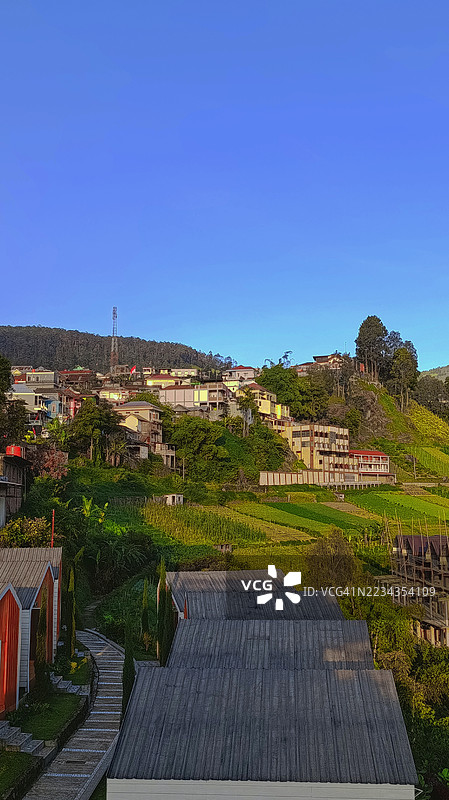 风景如画的山坡村庄在晴朗的蓝天下图片素材
