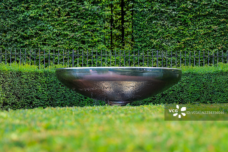郁郁葱葱的公园里的大金属碗图片素材