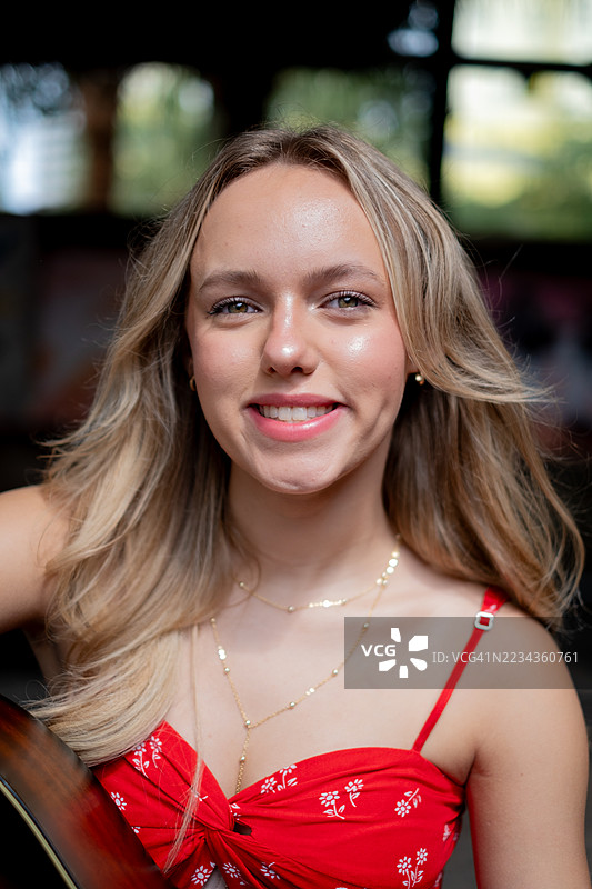 身穿红裙的年轻女子手持吉他图片素材