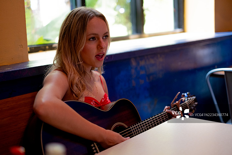 年轻女子在室内弹吉他图片素材