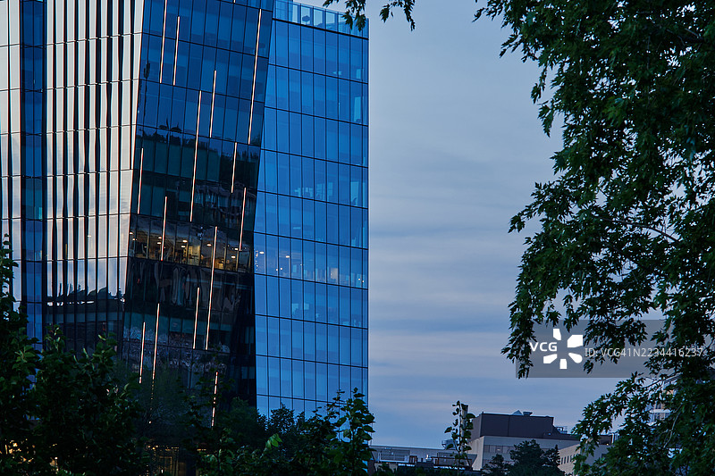 现代玻璃办公大楼在夜晚灯光下的景象图片素材