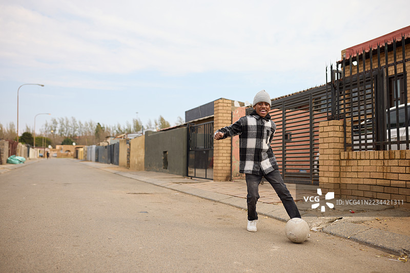 无忧无虑的孩子踢足球的全身照图片素材