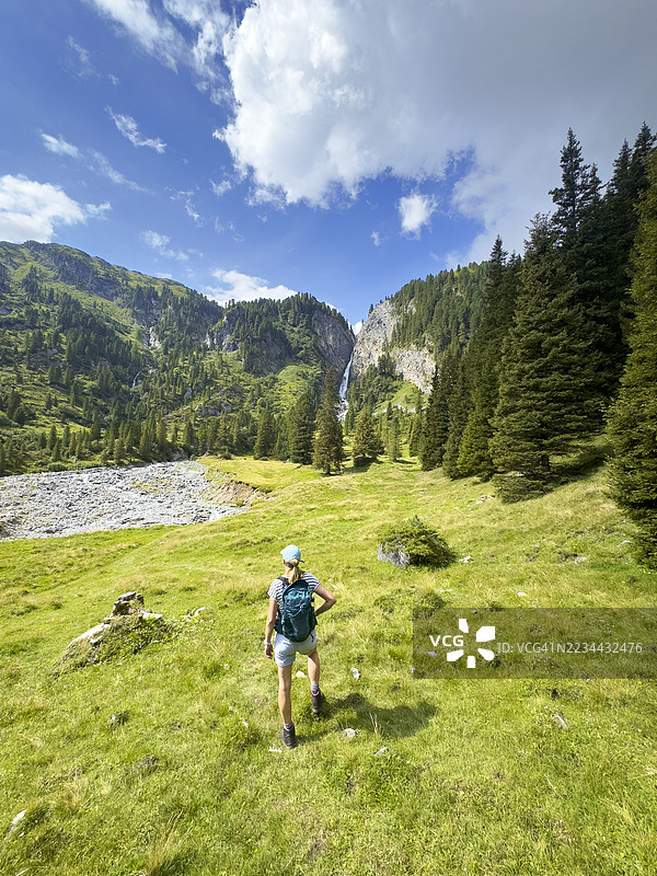 一位女性徒步旅行者在欣赏从亨特图克斯冰川瀑布下方俯瞰亨特图克斯山谷的美景。图片素材