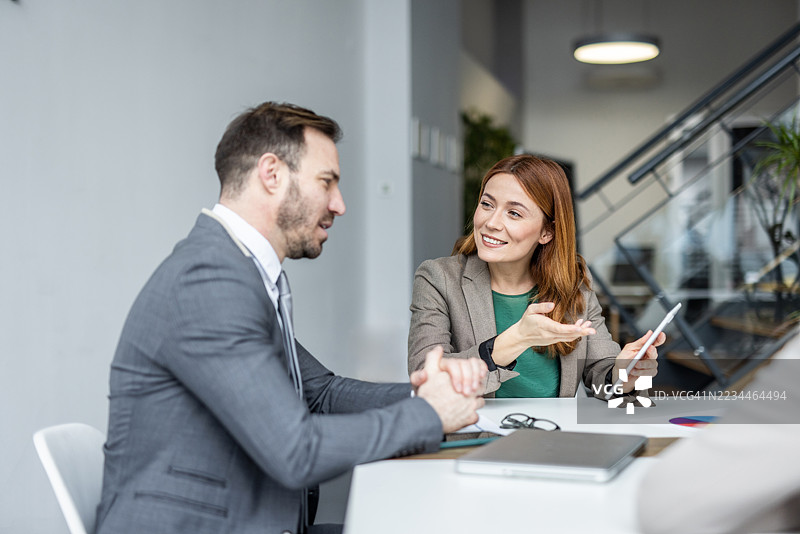 女商人在会议中向男商人展示数字平板电脑图片素材