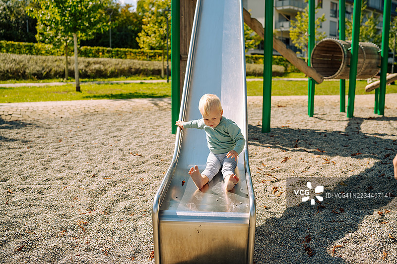幼儿从游乐场滑梯上滑下图片素材