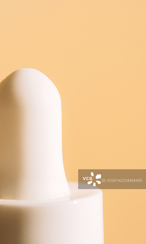 简约的白色滴管盖与柔和背景的特写镜头图片素材