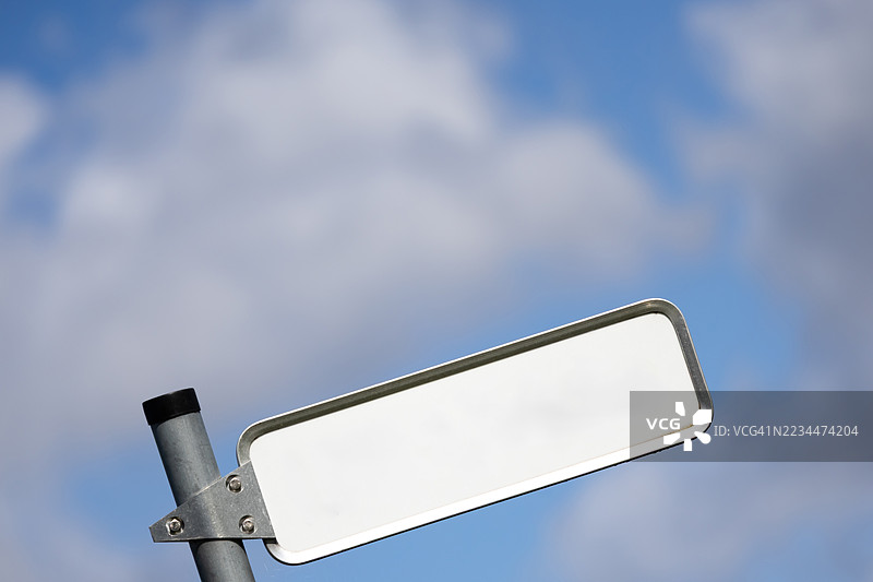 倾斜的空白白色路标，背景是云朵和天空图片素材