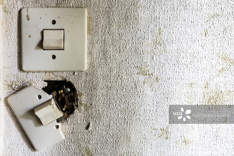 一座废弃建筑墙上的两个旧电开关图片素材