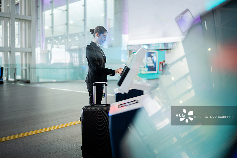 年轻女商人正在办理登机手续，同时在机场进行面部识别图片素材