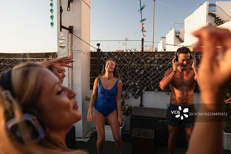 一群朋友在日落时分的屋顶上享受静音派对图片素材