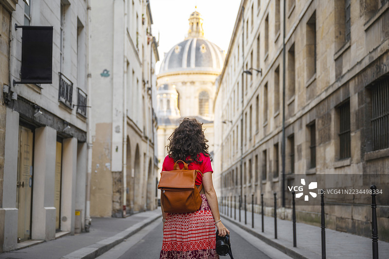 女人在巴黎探索，背景是法国学院圆顶。图片素材