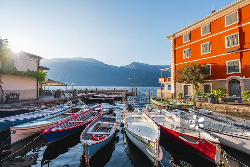 五彩斑斓的船只停靠在宁静的湖畔小村庄，意大利利蒙湖。图片素材