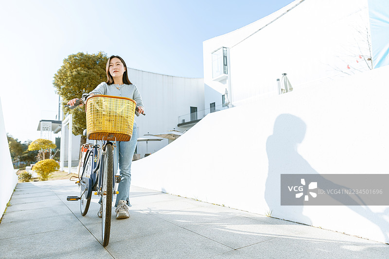 一位亚洲女性在乡村骑自行车图片素材