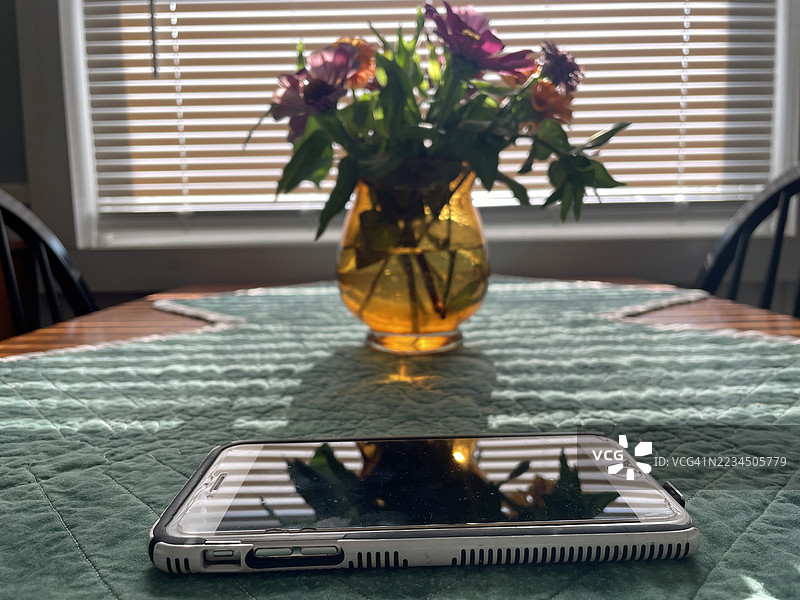 桌子上的iPhone与花朵图片素材