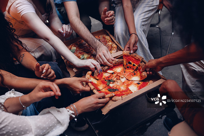 在充满欢声笑语的披萨之夜捕捉到的友谊时刻图片素材