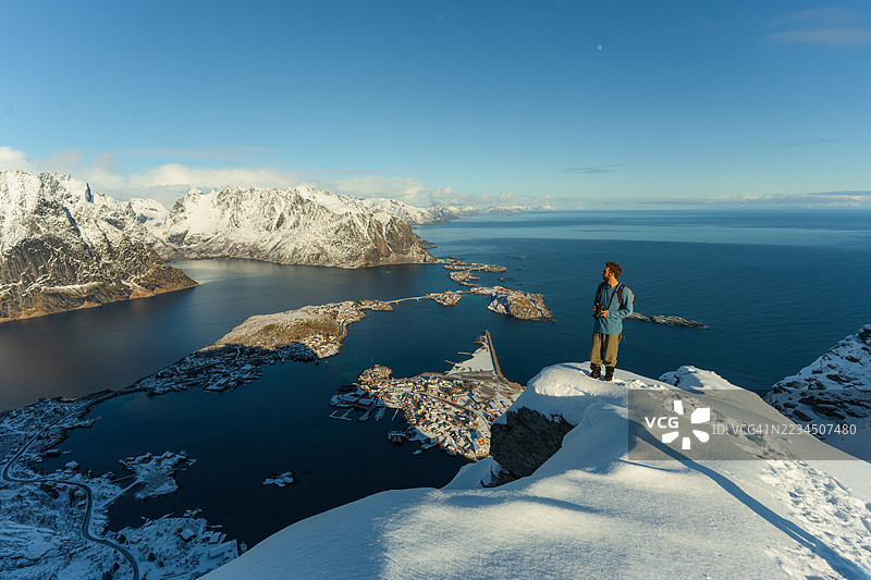 冬季在洛福滕群岛旅行时，一名男子在雷纳布林根山上徒步旅行图片素材
