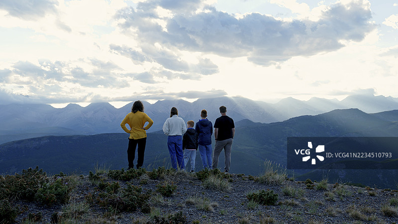 一家人在日落时分探索山脊顶端图片素材