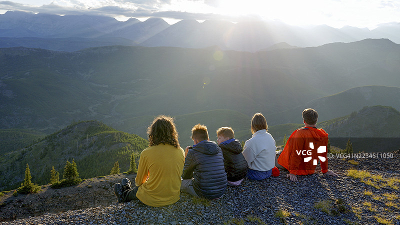 一家人在日落时分探索山脊顶端图片素材