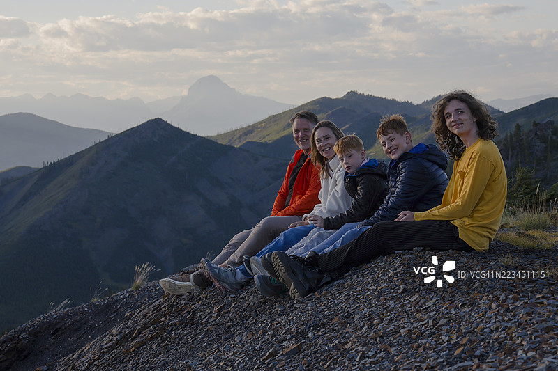 日落时分，家庭在山脊顶上的肖像图片素材