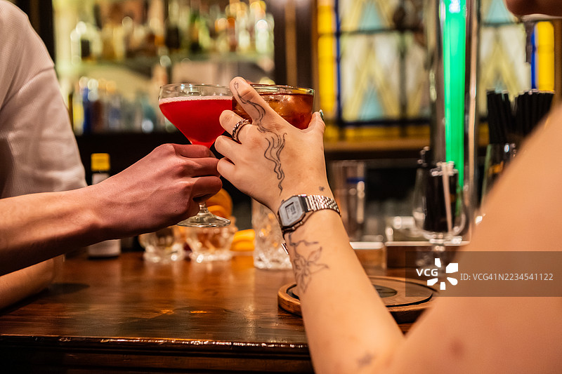 一对情侣在酒吧举杯祝酒的特写镜头图片素材