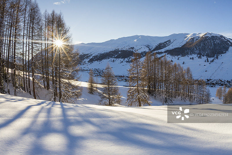 冬日阳光照耀在白雪覆盖的山脉上图片素材