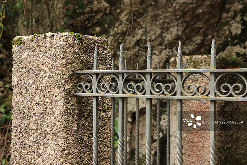 锈蚀的金属围栏连接在混凝土柱上图片素材