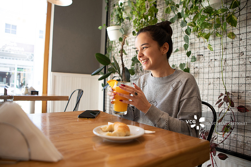 美丽微笑的盲人年轻女性在咖啡馆享用早餐图片素材