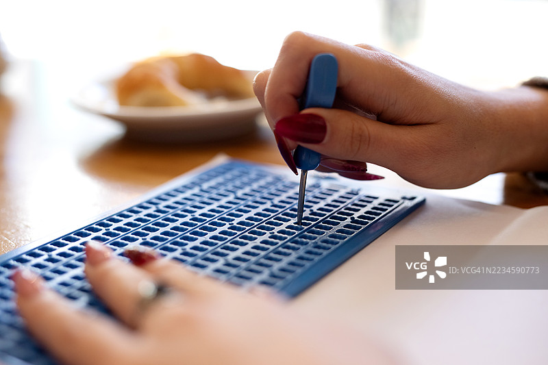 盲人女性的手在纸上书写盲文的特写镜头图片素材